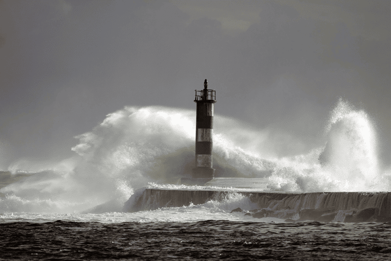 Bild eines Leuchtturms mit hohen Wellen als Sinnbild für die raue Berufsweld bei mind4service von ITSM Partner